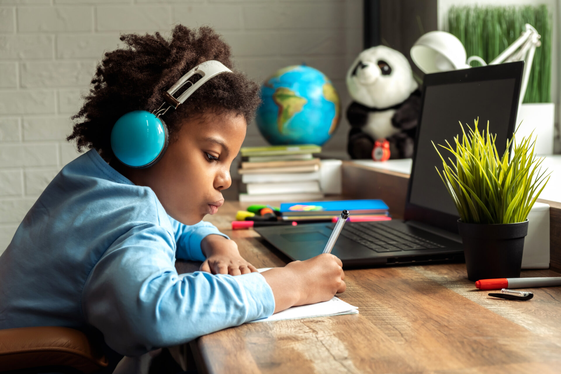 Young girl doing homework to illustrate great tech products for back to school