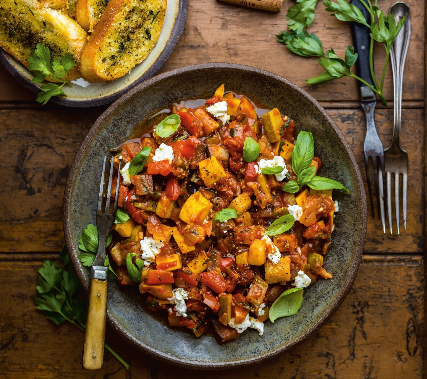 plate of ratatouille with cheese and garlic bread