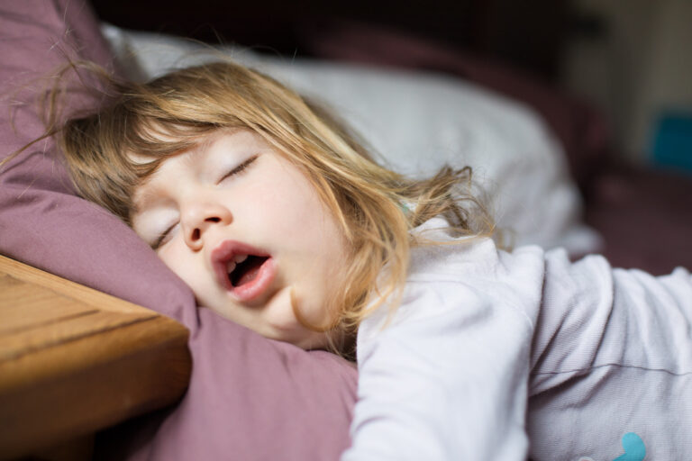 Toddler sleeping open-mouthed, to illustrate the question "Is my kid sleeping too much?"