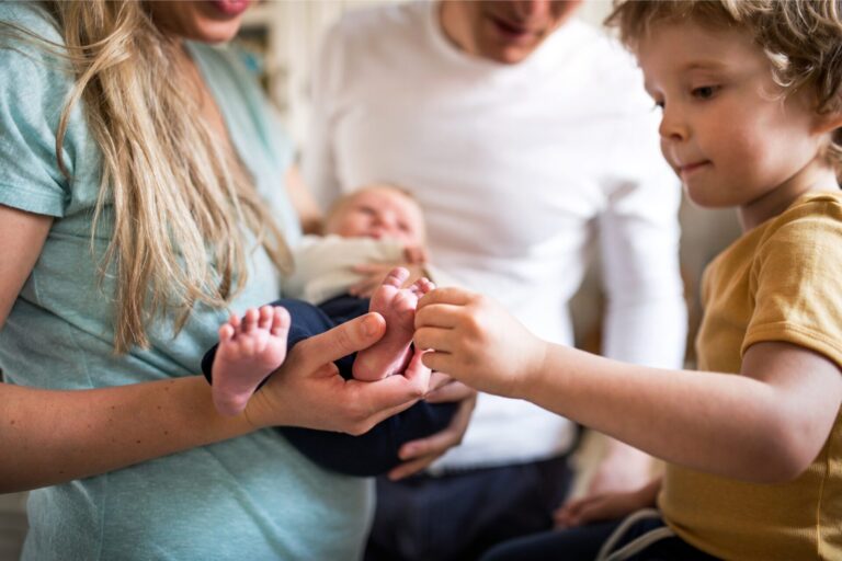 Preschooler meeting their new baby sibling with mom and dad