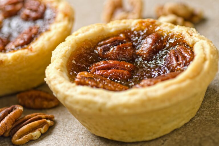 A pecan butter tart sits on a plate