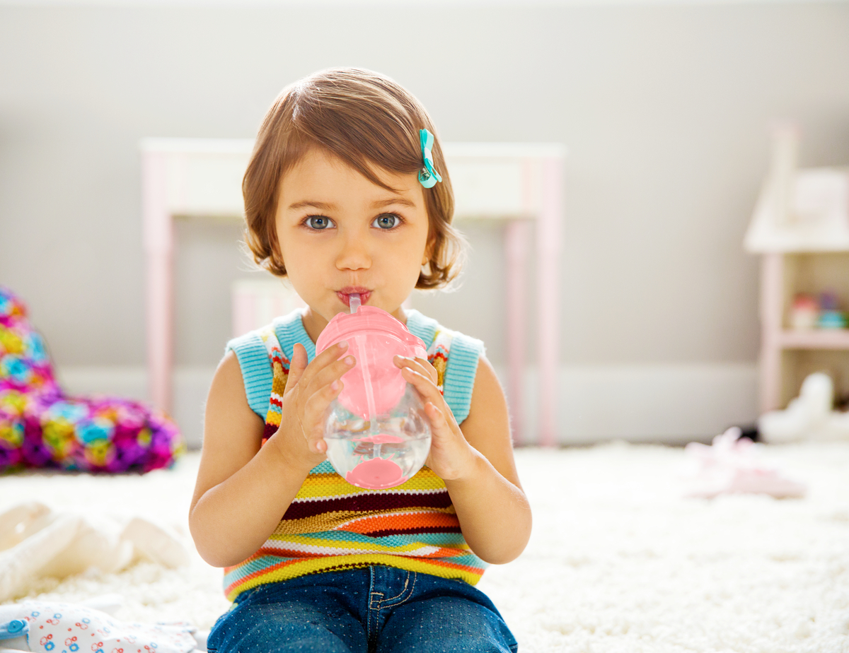 toddler drinking from cup with straw