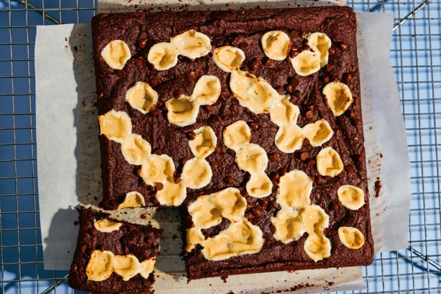 A cooling rack with toasted marshmallow-topped brownies