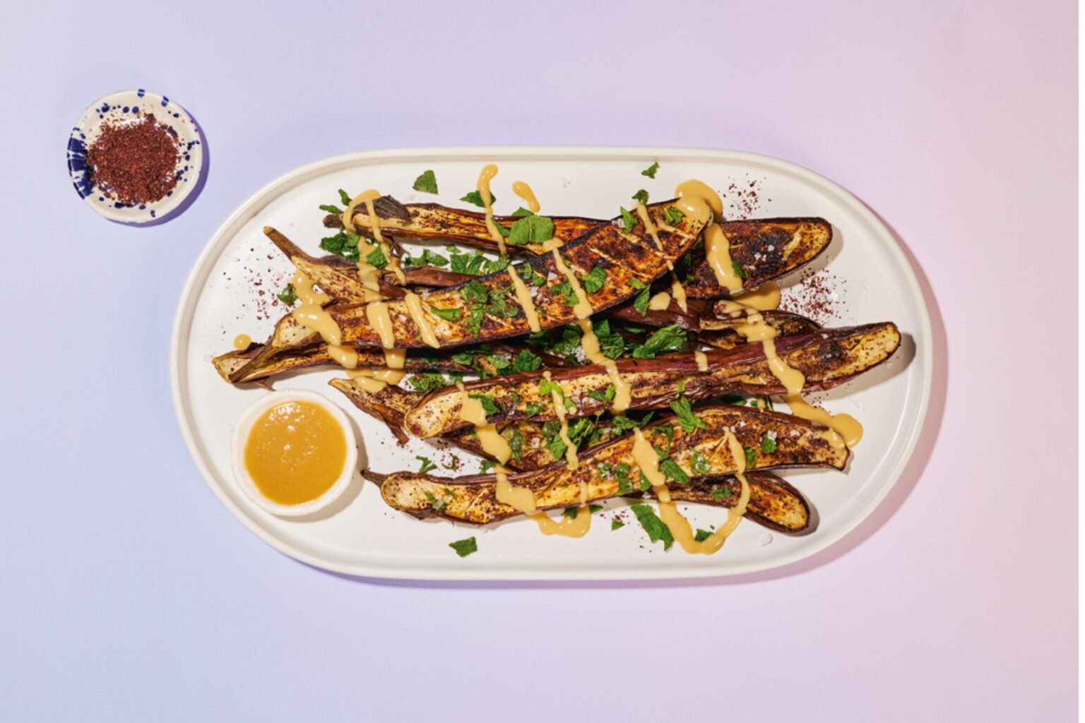 A plate of roasted eggplant with tahini drizzle