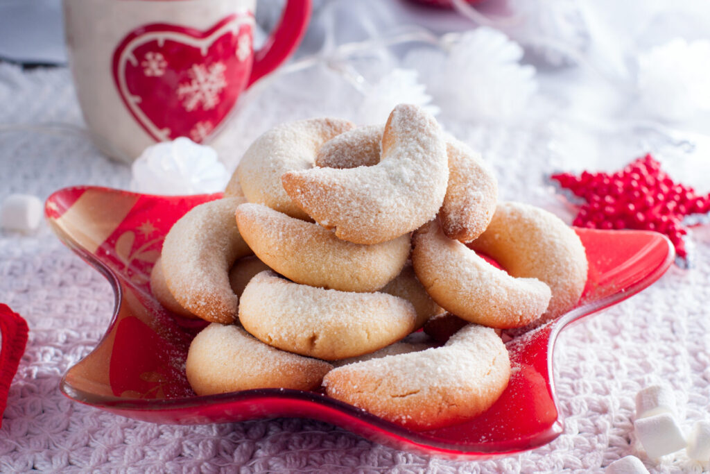 Vanilla crescent cookies sitting on a red, star-shaped plate