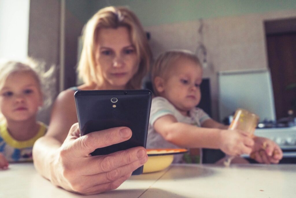 Woman on phone with children, to illustrate if AI can make you a better parent