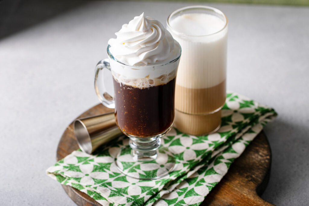 Irish coffee in a glass mug sitting on a green-and-white napkin