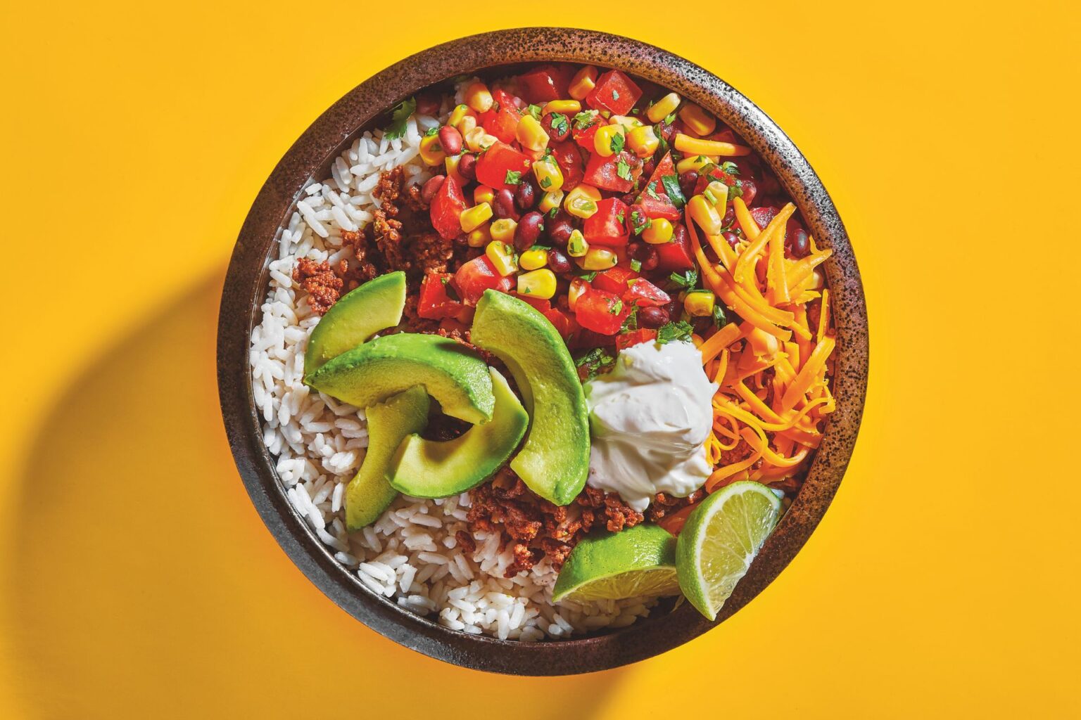 A burrito bowl filled with feat and veggies
