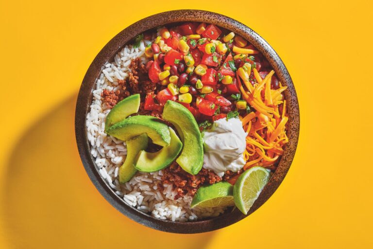 A burrito bowl filled with feat and veggies