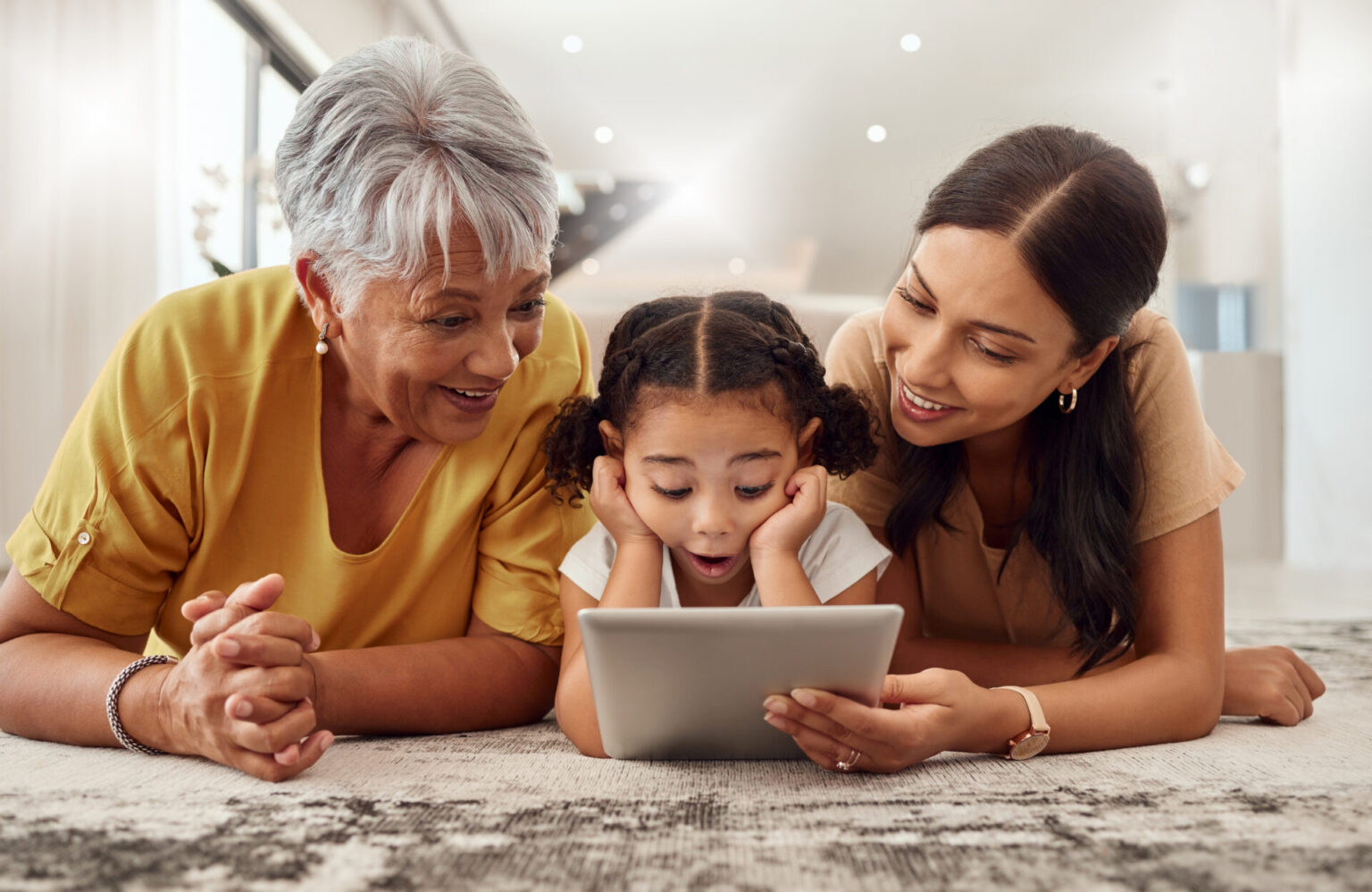 Three generations looked at a tablet, to illustrate how grandparenting today requires rules