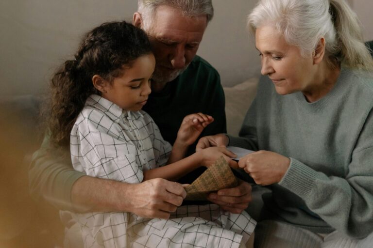 Grandchild sitting with grandparents, to illustrate redefining what it means to be a step-grandparent