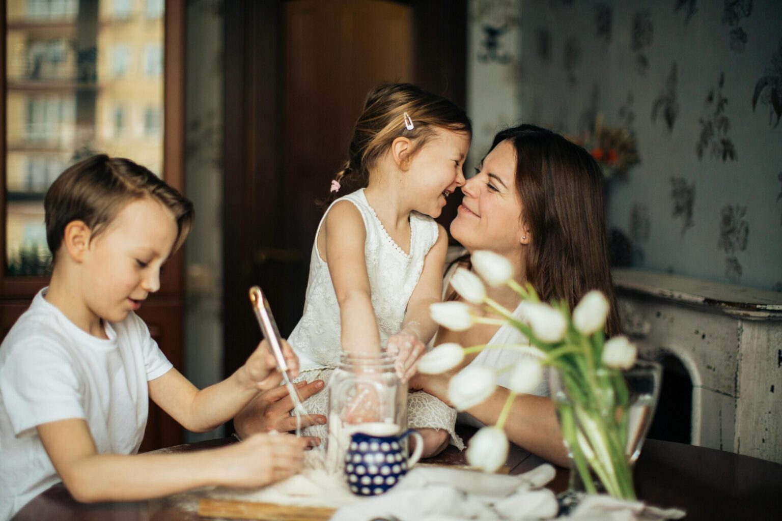Smiling mom and children baking, with flowers in the foreground, to show "the joy effect"