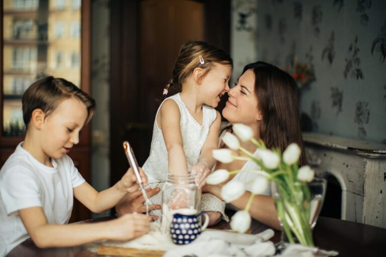 Smiling mom and children baking, with flowers in the foreground, to show "the joy effect"