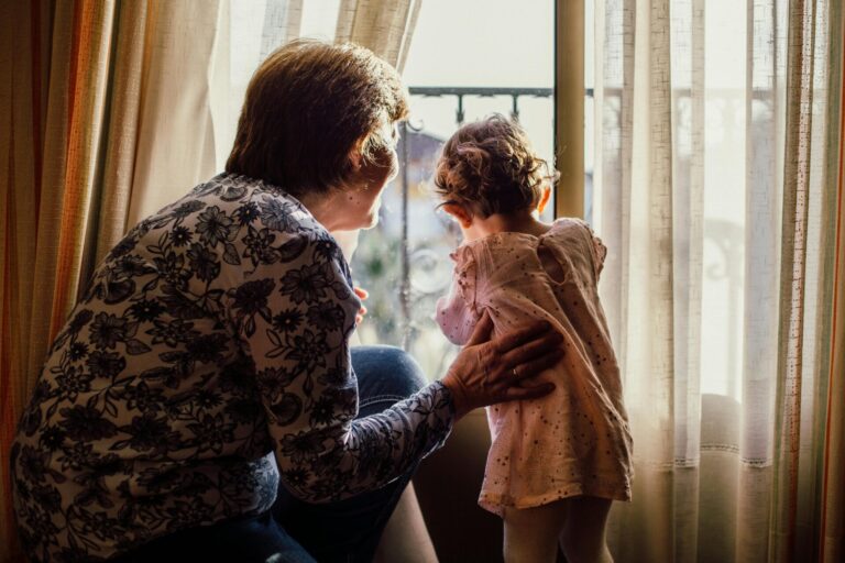 Grandparenting questions, answered, illustrated by grandmother and granddaughter look out the window