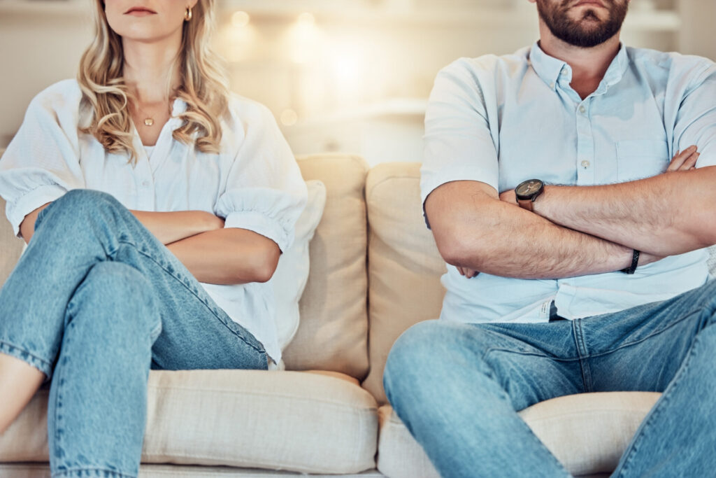 A couple sitting cross-armed, to show that their efforts to show love are missing the mark