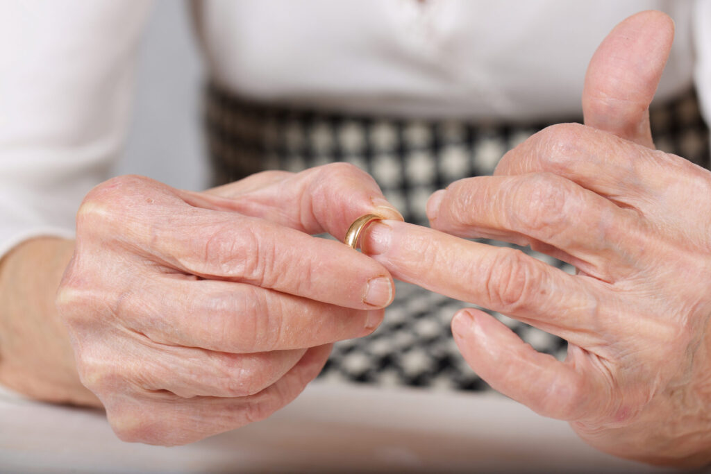 Woman removing her wedding ring to illustrate grey divorce