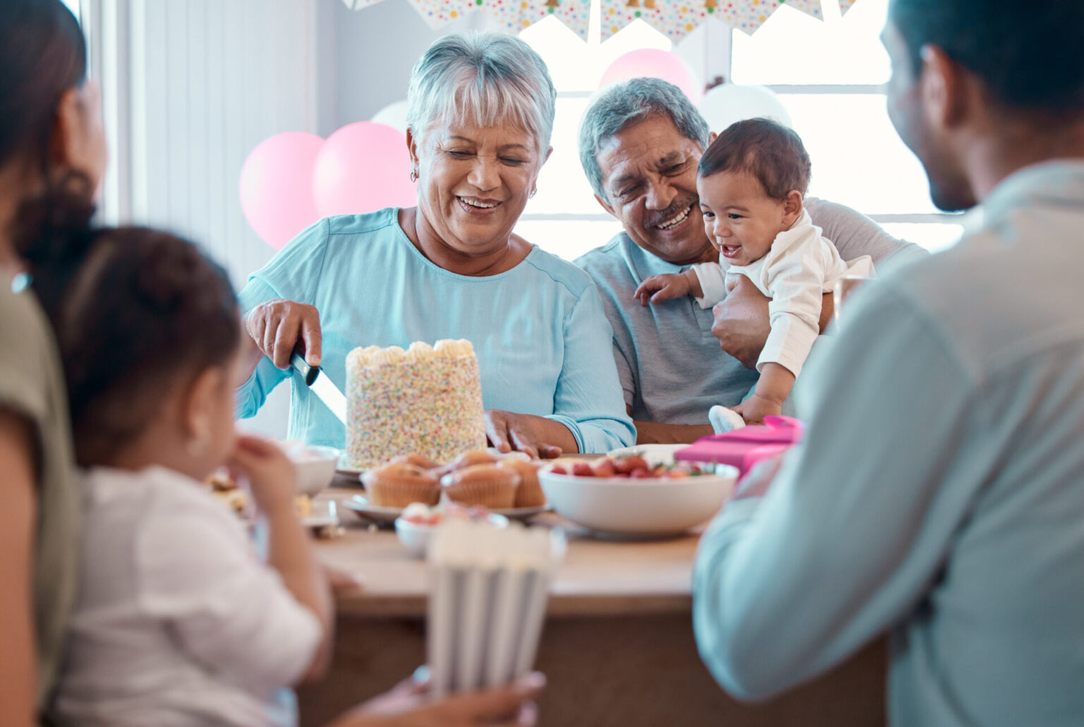 Grandmother and grandfather serving cake at a grandparent baby shower