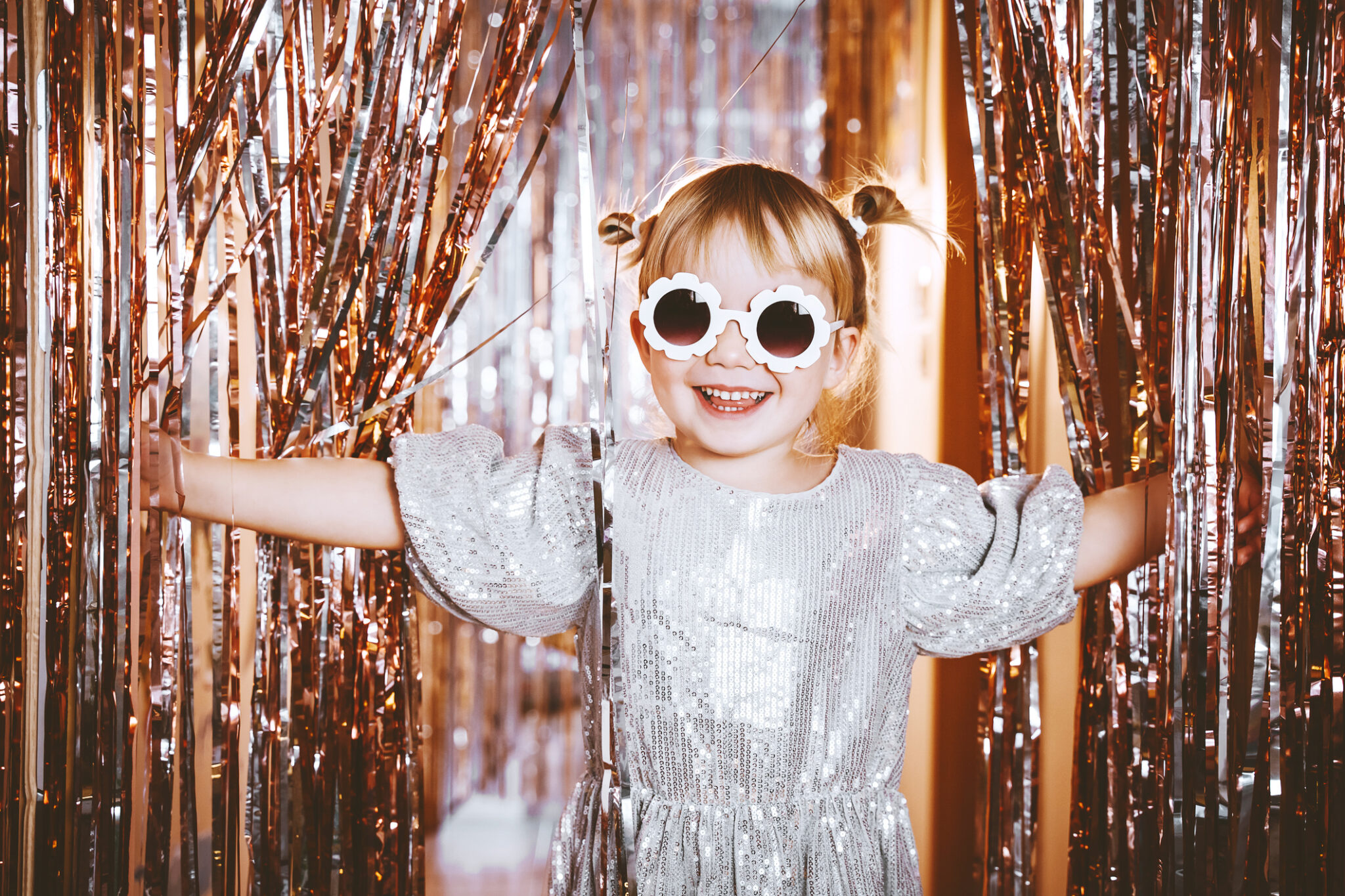 Kid wearing a sparkly dress and funny sunglasses to show an Academy Awards party