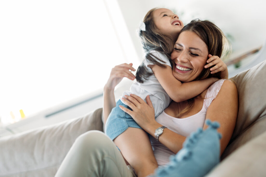 new mom hugging daughter on the couch considering life insurance 