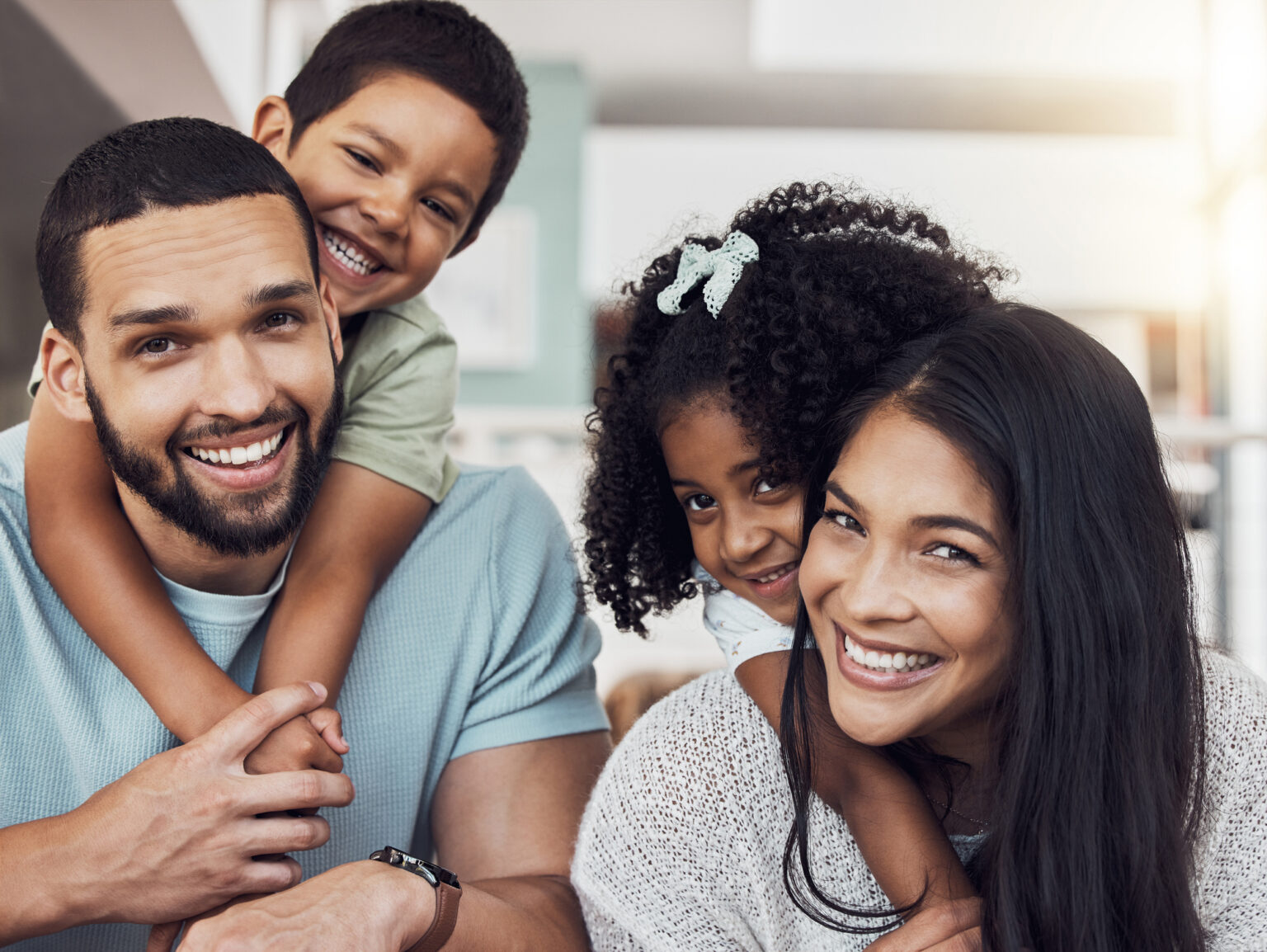 Parents and two children posing for the camera, to illustrate that many families are choosing to use Mom's last name