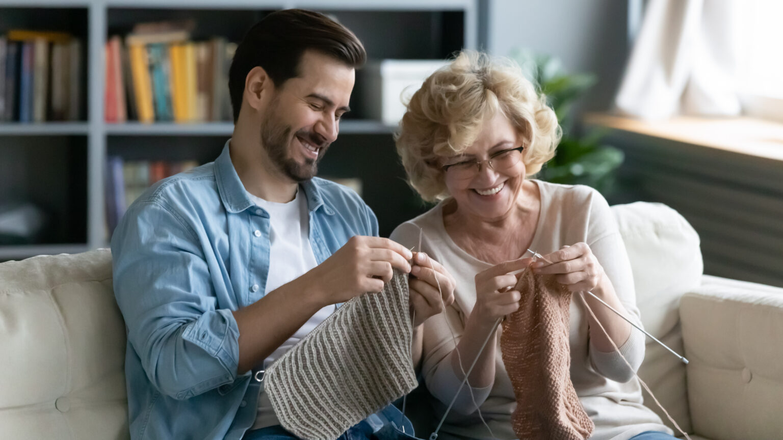 Grandparent and Gen Z man knitting to illustrate "grandma hobbies"