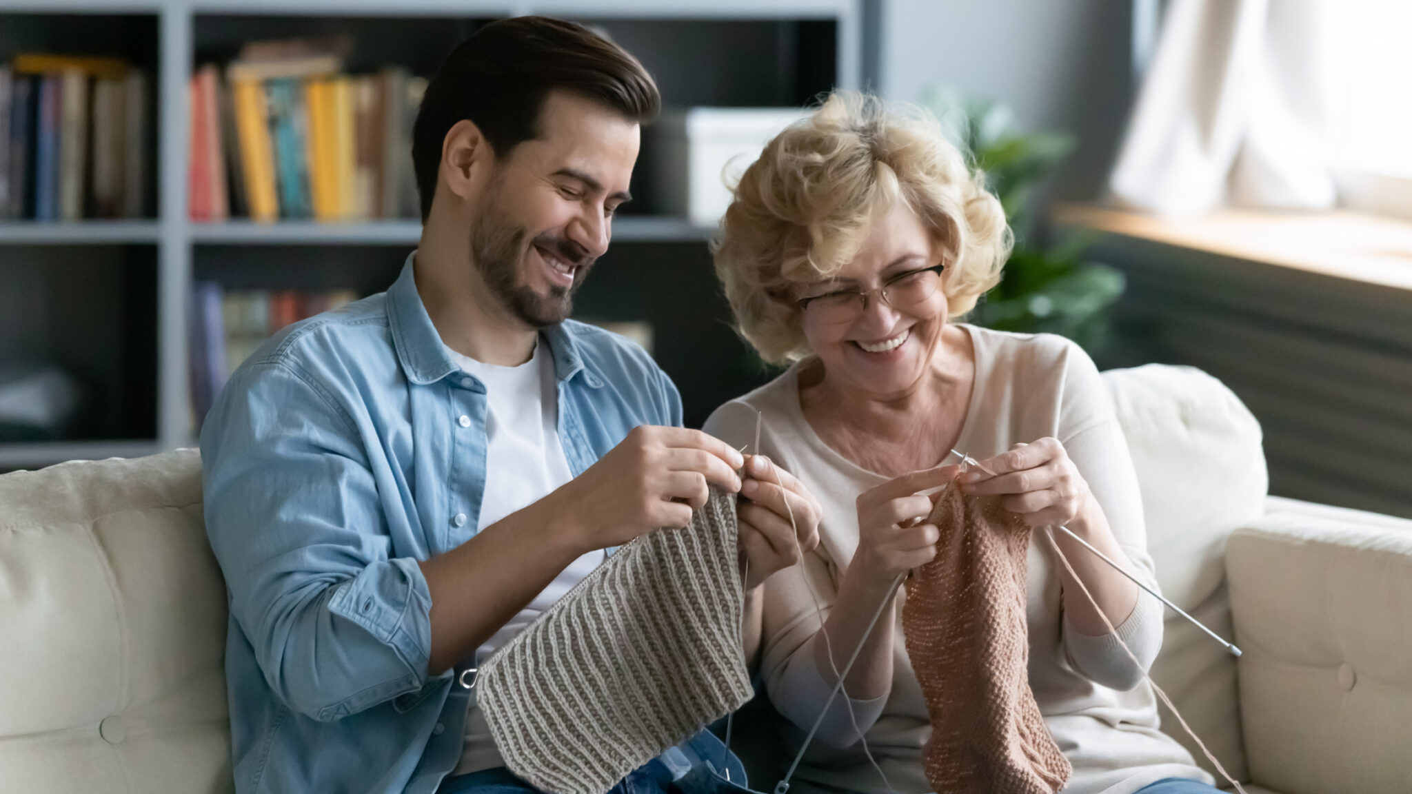 Grandparent and Gen Z man knitting to illustrate "grandma hobbies"