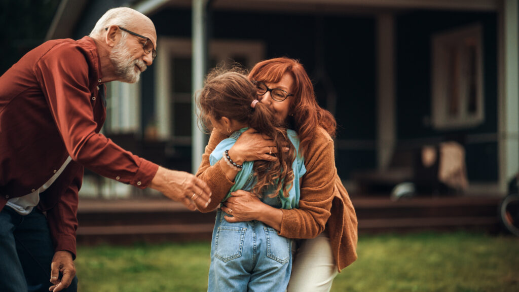 Grandparents hugging grandchild, to illustrate grandparent rights in Canada