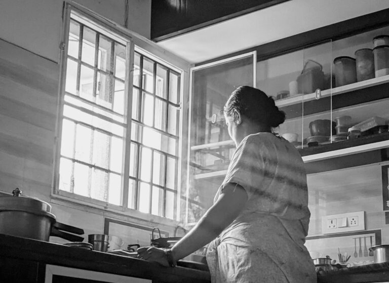 A woman standing at a sink depicting the loneliness of being a type a parent