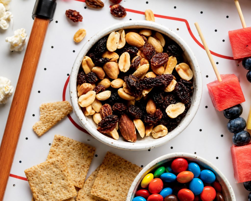 Tasty trail mix in a white ramekin with M&Ms and fruit on the side