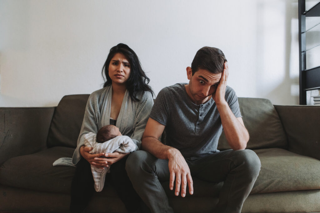 Tired parents holding infant, wondering about soulmate culture and their marriage