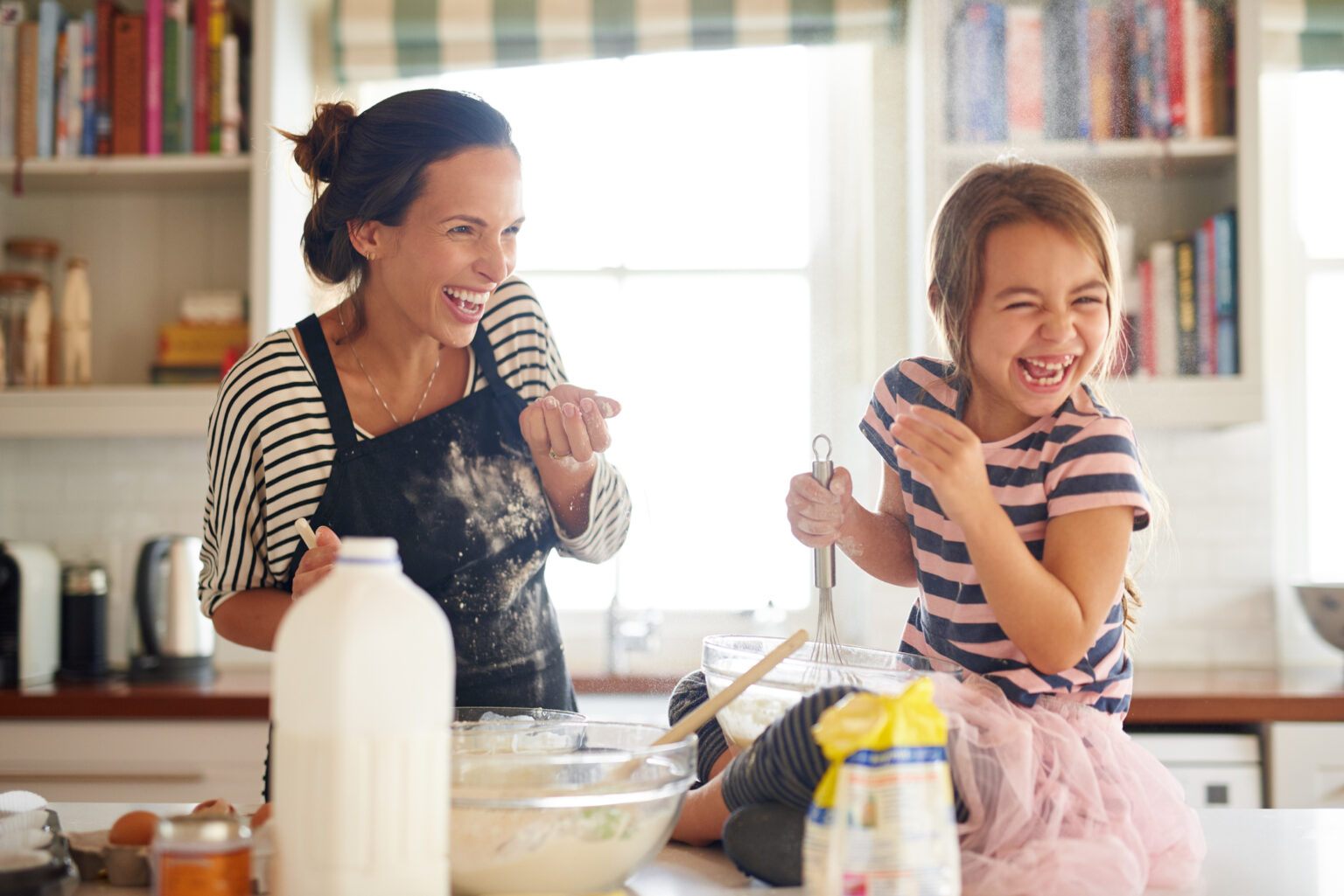 Mom and daughter playing in the kitchen, to illustrate that some parenting rules are meant to be broken