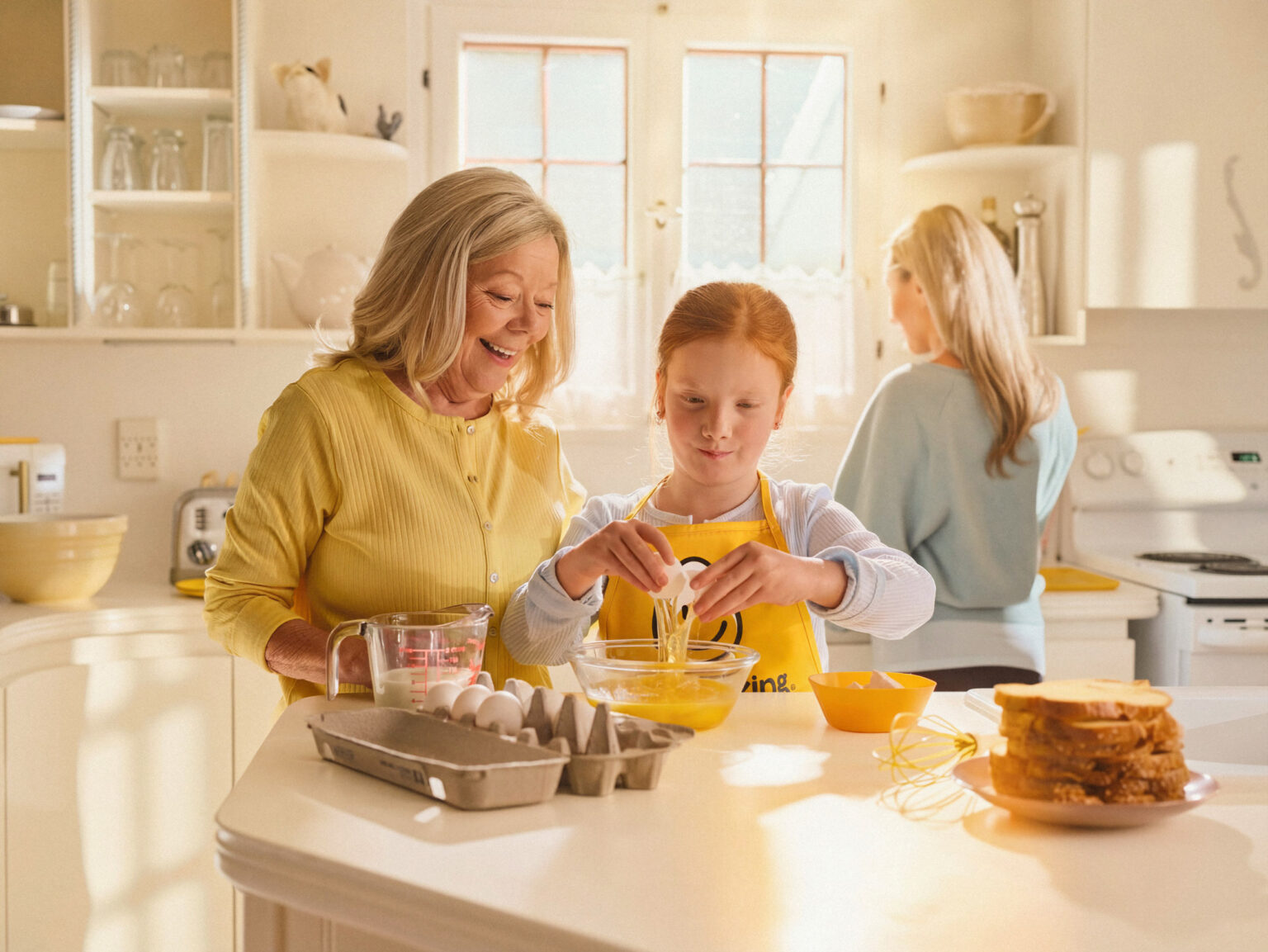 Grandparent cracking eggs with grand daughter
