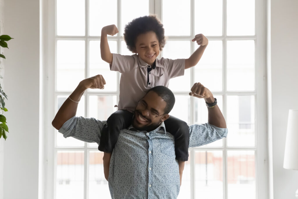 Father and son flexing muscles to show strong bone health in kids