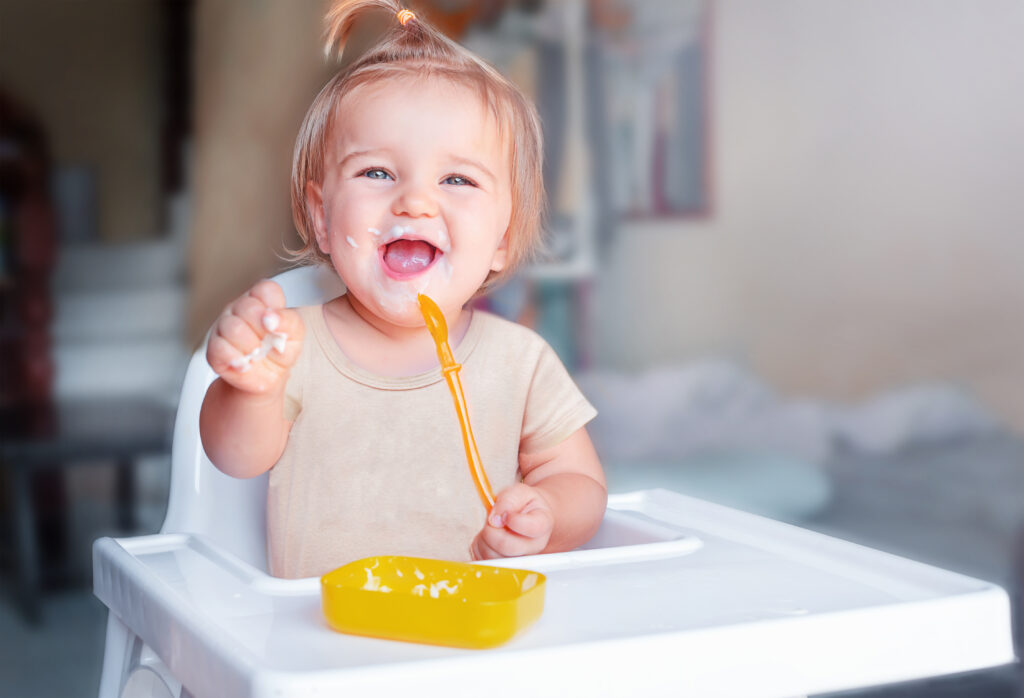 Baby eating solid food on their own.