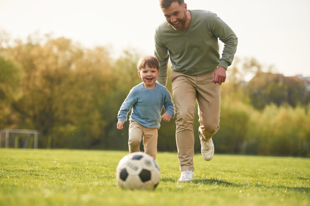father son playing soccer for good bone health for kids