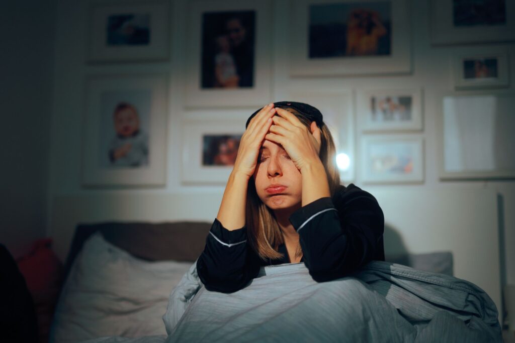 Stressed out parent sitting in bed