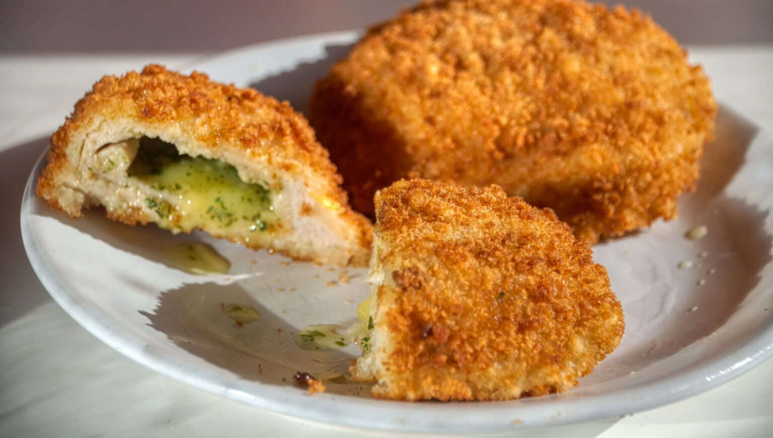 Golden chicken kiev cut in half to show garlic-butter stuffing.