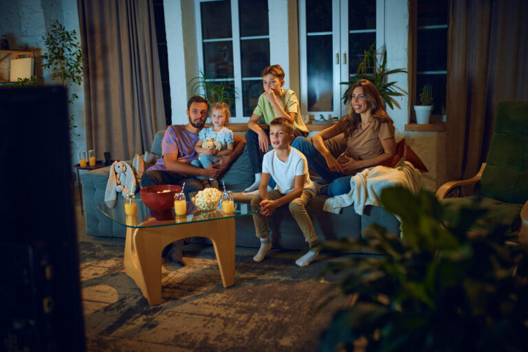 Family watching a movie with popcorn, to illustrate movies from the '80s, '90s and 2000s