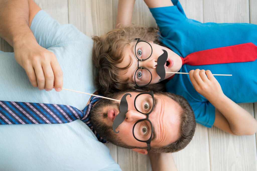 A dad and kid with funny moustaches, to show "whimsymaxxing"